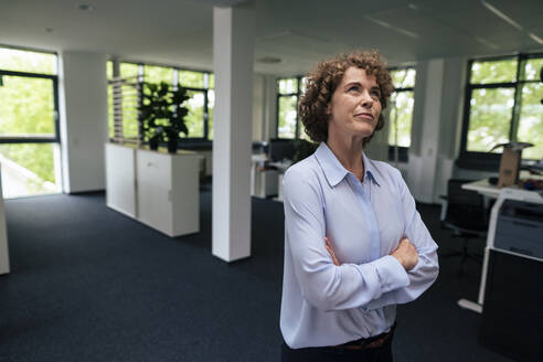 Businesswoman standing with arms crossed in office - JOSEF11271