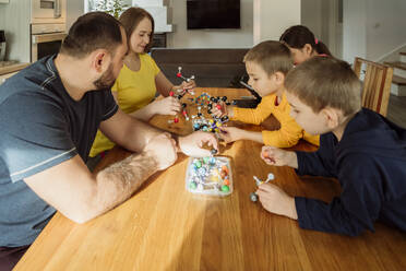 Eltern und Kinder mit Molekularstrukturen auf dem Tisch zu Hause - OSF00424