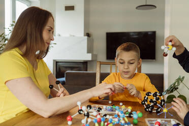 Mother teaching boy about molecules at home - OSF00431