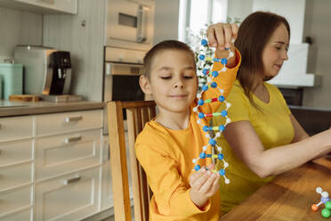 Junge hält DNA-Modell von Mutter zu Hause - OSF00436