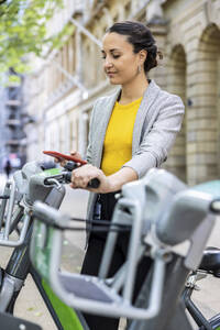 Geschäftsfrau vermietet Elektrofahrrad über ihr Smartphone - WPEF06234