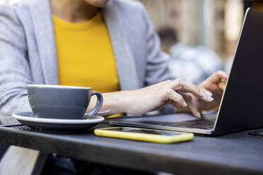 Hände einer Geschäftsfrau mit Laptop in einem Straßencafé - WPEF06250