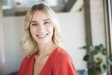 Happy businesswoman with blond hair in office - UUF26960