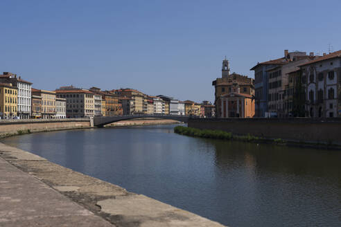 Italien, Toskana, Pisa, Arno-Kanal mit Wohngebäuden und Brücke im Hintergrund - LOMF01342