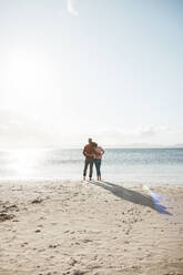 Mature couple standing at beach on sunny day - JOSEF11326