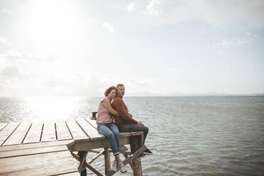 Älteres Paar sitzt auf dem Steg über dem Meer - JOSEF11329
