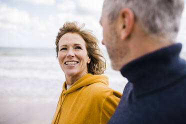 Glückliche reife Frau mit Mann beim Spaziergang am Strand - JOSEF11356