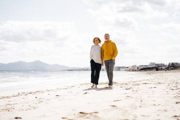 Mature couple walking on shore at beach - JOSEF11409