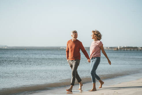 Glückliches reifes Paar, das am Strand spazieren geht - JOSEF11430