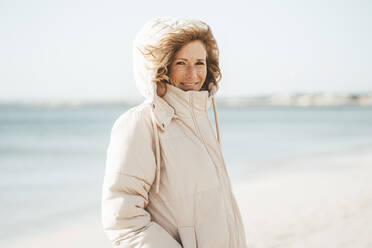 Lächelnde reife Frau am Strand stehend - JOSEF11437