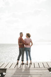 Mature couple with arm around standing on pier - JOSEF11445