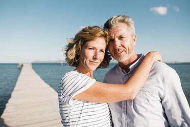 Smiling mature woman and man standing on jetty - JOSEF11487