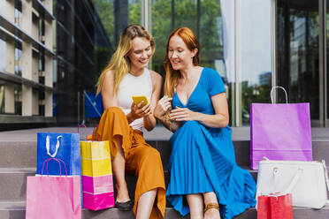 Frau teilt Smartphone mit Freund vor Einkaufszentrum - OIPF02079