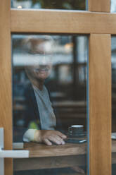 Älterer Geschäftsmann durch das Fenster eines Cafés gesehen - JOSEF11524