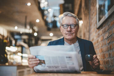 Älterer Geschäftsmann mit Zeitung bei einem Kaffee im Café - JOSEF11551