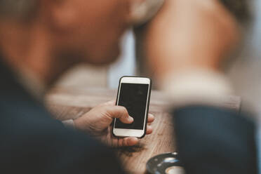 Geschäftsmann mit Smartphone im Cafe - JOSEF11587