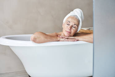 Frau mit geschlossenen Augen entspannt in der Badewanne - VEGF05764