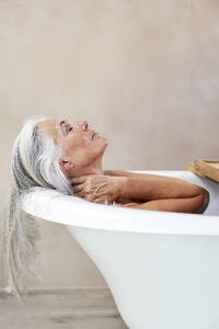 Woman taking bath in bathtub at home - VEGF05769