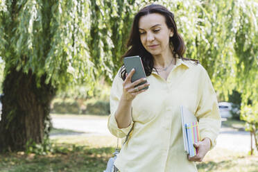 Frau mit Laptop und Tagebuch und Smartphone im Park - OSF00450