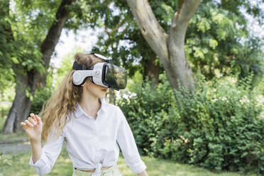 Mädchen trägt Virtual-Reality-Simulator im Park - OSF00453