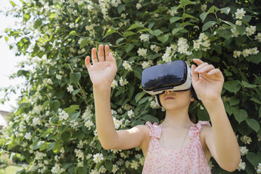 Mädchen mit VR-Brille vor einer blühenden Pflanze - OSF00457