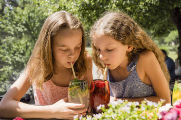 Mädchen mit Schwester trinkt Fruchtlimonaden - OSF00469