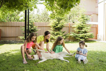 Mother and daughters with dog at back yard - OSF00476