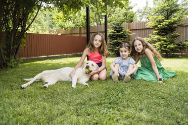Smiling girls with dog at back yard - OSF00493