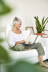 Mature woman using laptop at home - VEGF05798