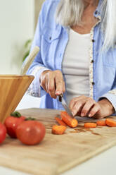 Frau schneidet Karotten in der Küche - VEGF05837
