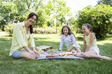 Happy mother with daughters having picnic at park - OSF00494