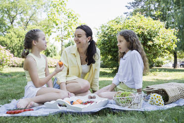 Happy daughters on picnic with mother in park - OSF00503