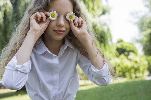 Mädchen bedeckt Augen mit Kamillenblüten - OSF00522
