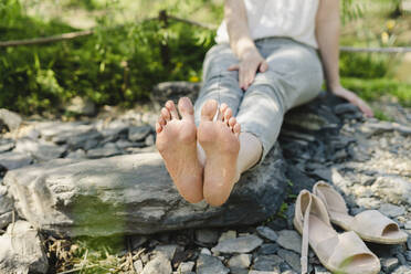 Woman relaxing on rocks in park - SEAF01086