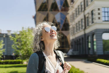 Glückliche Frau mit Sonnenbrille an einem sonnigen Tag - SEAF01087