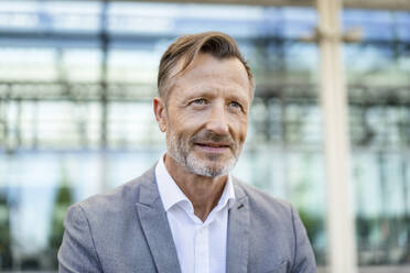 Contemplative mature businessman in front of building - DIGF18436