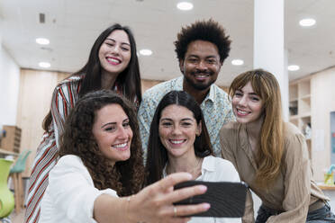 Glückliches Geschäftsteam macht Selfie im Büro - PNAF04218