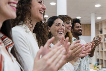 Happy business team clapping hands after a presentation in office - PNAF04221