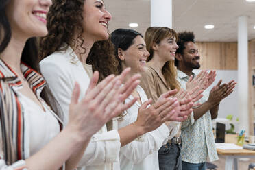 Happy business team clapping hands after a presentation in office - PNAF04222