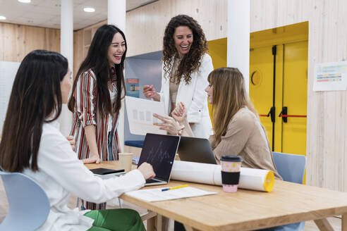 Ein Team glücklicher Geschäftsfrauen bei einem Treffen im Büro - PNAF04243