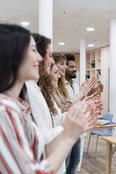 Business team clapping hands after a presentation in office - PNAF04271