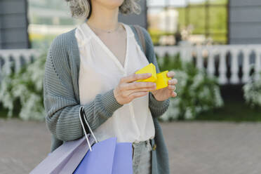 Hands of woman holding yellow gift box - SEAF01094