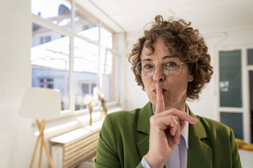 Geschäftsfrau mit Finger auf den Lippen im Büro - JOSEF11663