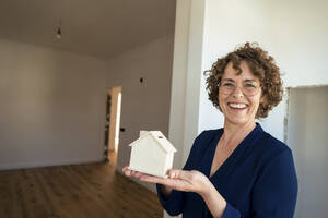 Glücklicher reifer Immobilienmakler mit Musterhaus im neuen Zuhause - JOSEF11701