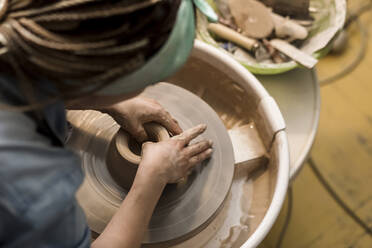 Potter moulding bowl on pottery wheel - LLUF00796