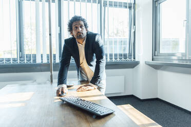 Businessman scrolling computer mouse on desk in office - JOSEF11770