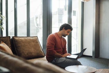 Geschäftsmann mit Laptop bei der Arbeit im Büro - JOSEF11814