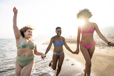 Unbeschwerte multirassische Frauen haben Spaß am Strand an einem sonnigen Tag - OIPF02137