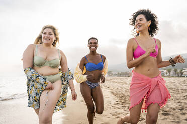 Unbeschwerte multirassische Frauen haben Spaß am Strand - OIPF02139