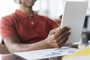 Hands of businessman holding tablet PC at desk in office - JCICF00301